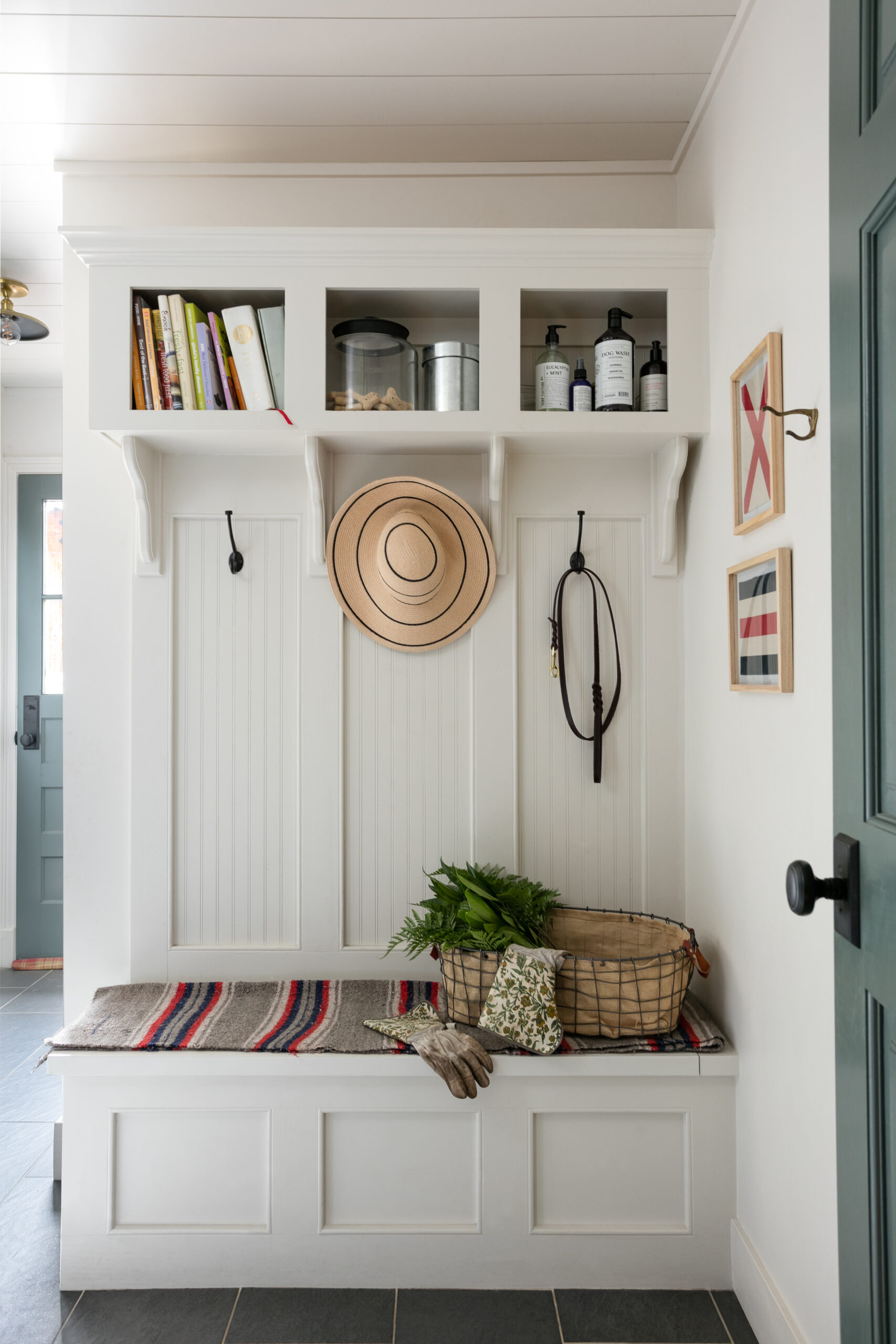 Mudroom spring bench with hat, leash, plants, gloves and other filler items.