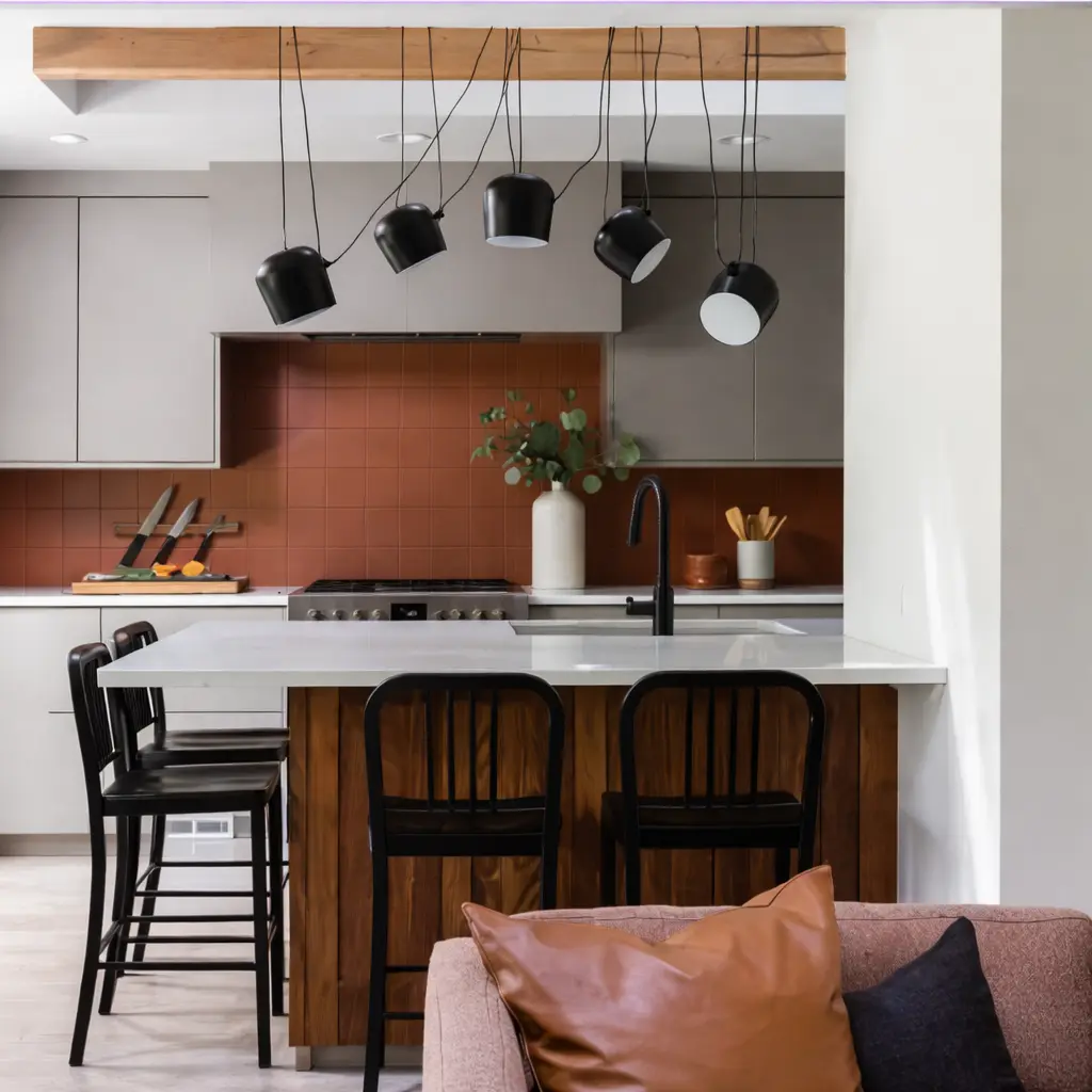 Kitchen with gray cabinetry, a copper tile backsplash, and black pendant lights in The Alford Dwelling renovation by Forge & Bow