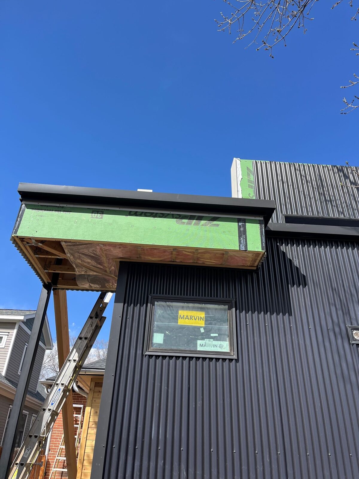 Construction in progress on a cantilevered roofline addition, a Forge & Bow new build