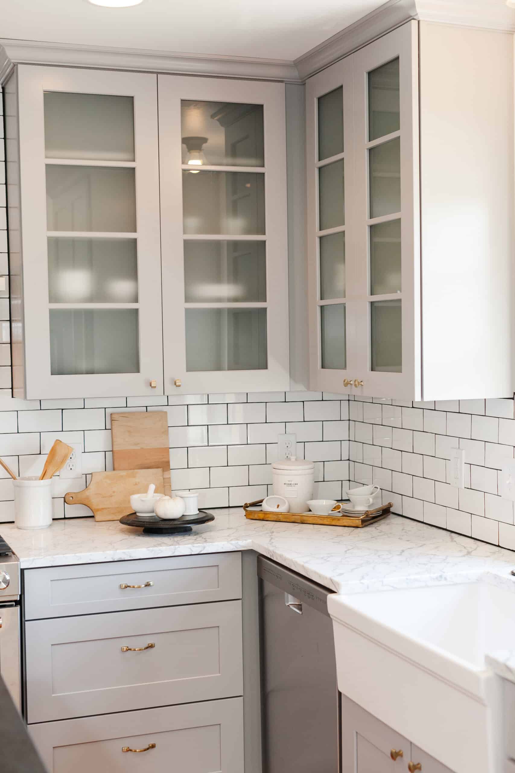 Kitchen corner with glass-front cabinets and white subway tile backsplash in The Circle Residence renovation by Forge & Bow