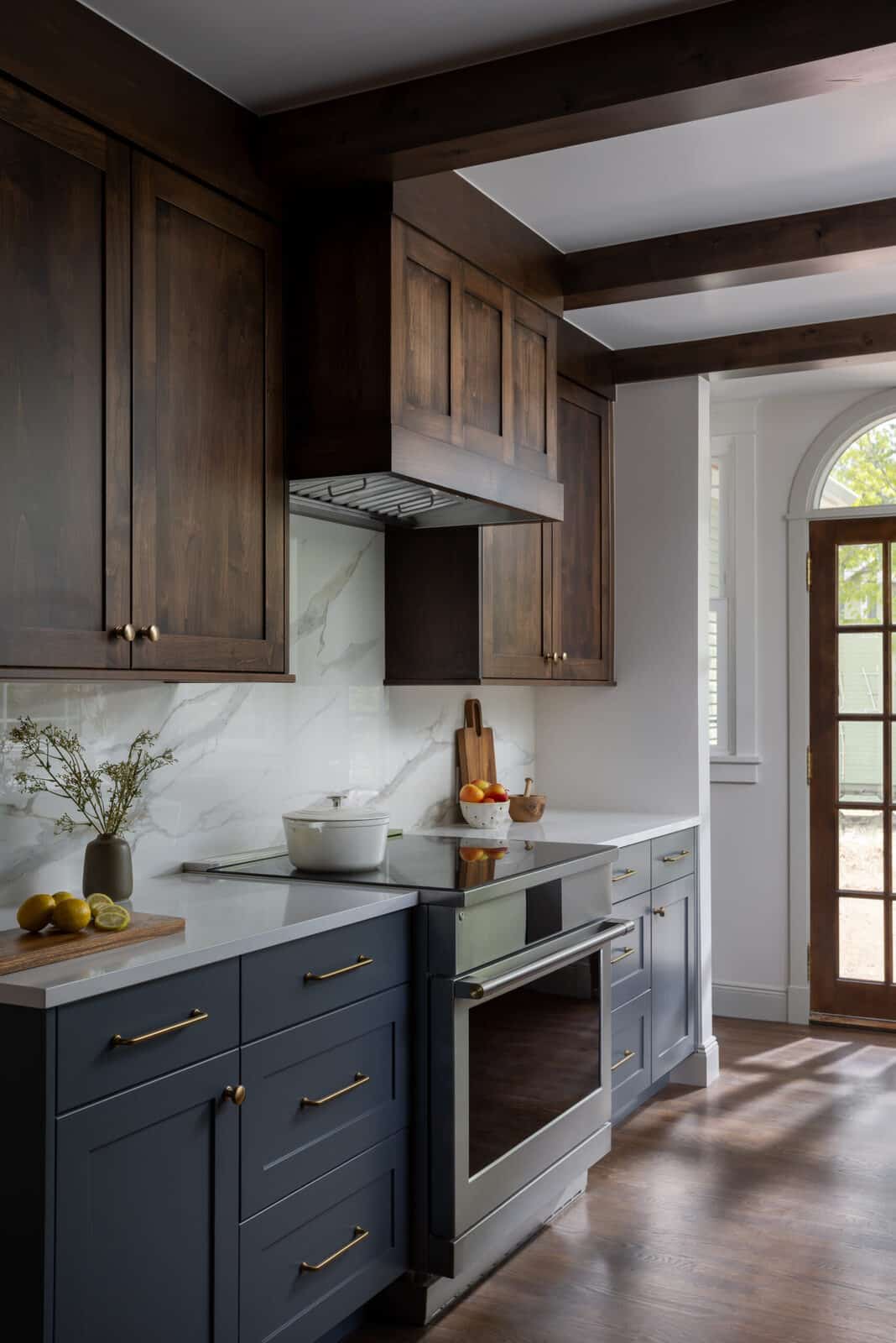 Kitchen with dark wood cabinetry and a wood range hood in the Smith renovation by Forge & Bow